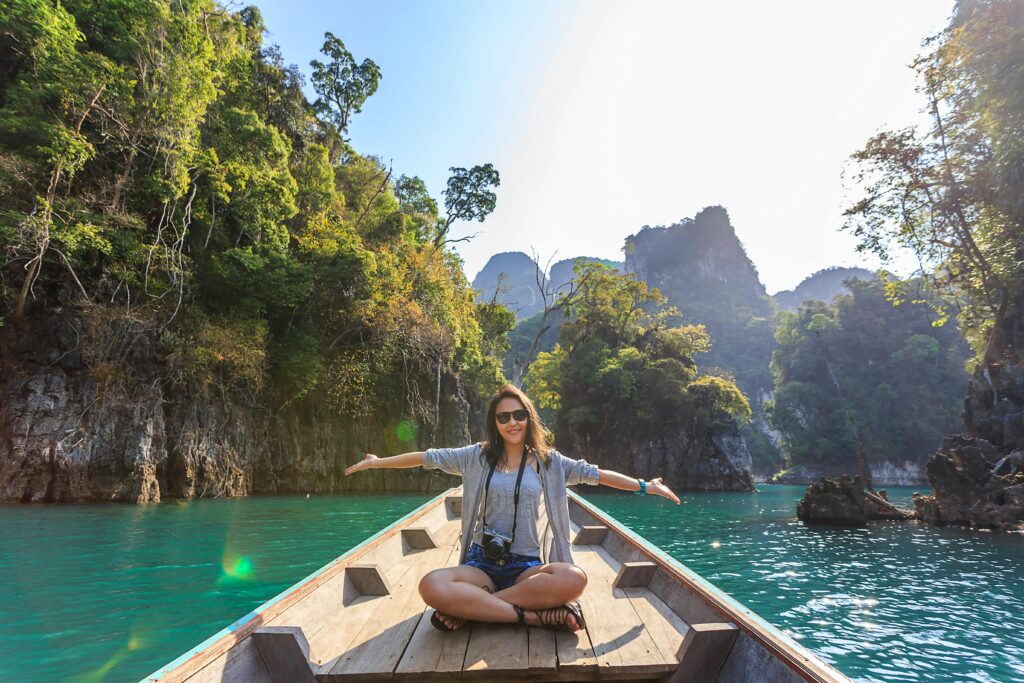 pexels photo 1371360 1371360 Asian woman relishing a serene boat journey through the lush karst landscape of Thailand's Khlong Sok.